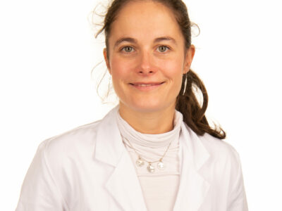 Femme médecin en blouse blanche souriant