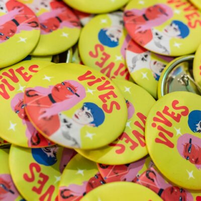 Badge jaune avec illustrations colorées 'Vives'.