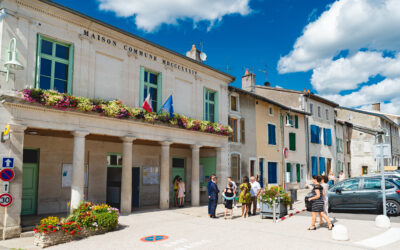 Mairie avec fleurs et personnes devant.