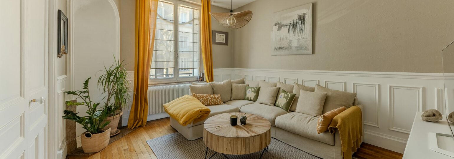 Séjour lumineux appartement Nancy Airbnb – canapé, table basse, lumière naturelle
