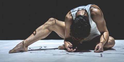 Danseur en pose expressive sur scène.