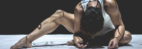 Danseur en pose expressive sur scène.