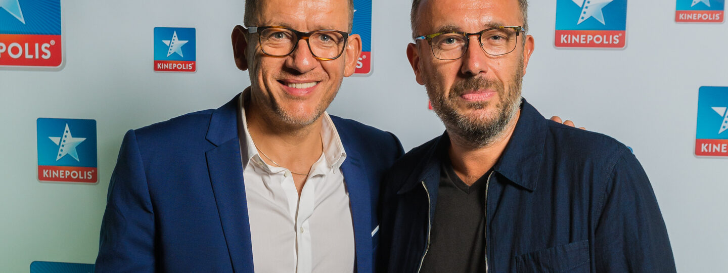 Deux hommes devant un logo Kinepolis.