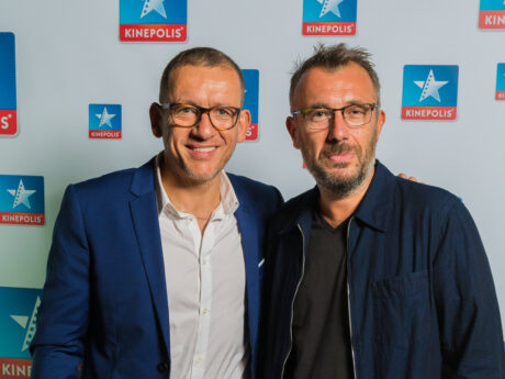 Deux hommes devant un logo Kinepolis.