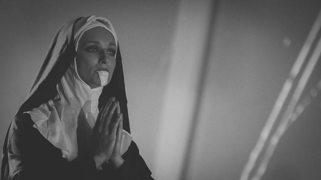 Religieuse en prière portant une robe noire.