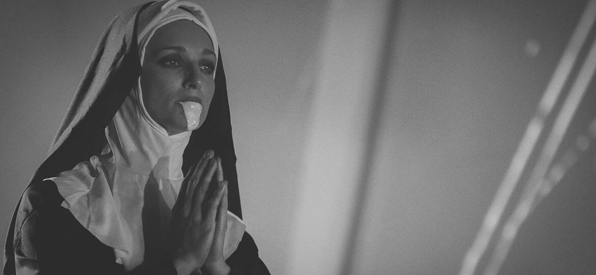Religieuse en prière portant une robe noire.
