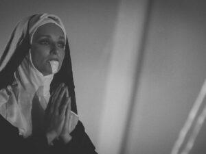 Religieuse en prière portant une robe noire.