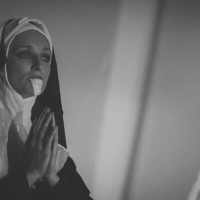 Religieuse en prière portant une robe noire.