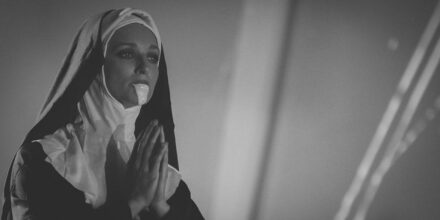 Religieuse en prière portant une robe noire.