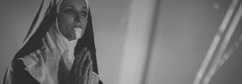 Religieuse en prière portant une robe noire.