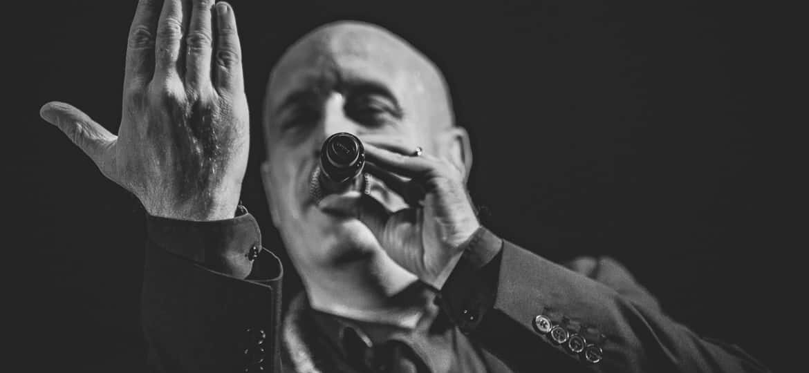 Chanteur en noir et blanc sur scène.