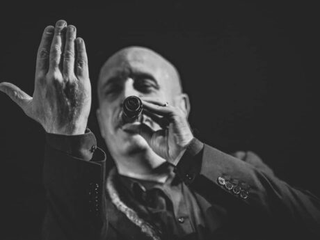 Chanteur en noir et blanc sur scène.