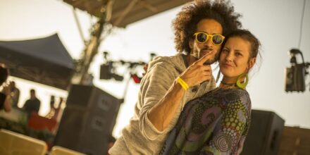 Couple souriant lors d'un concert en plein air.