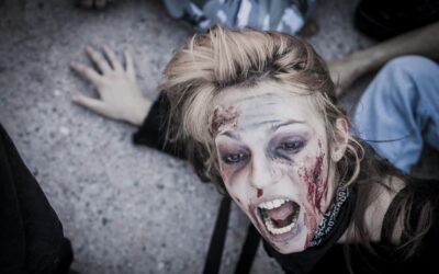 Personne maquillée en zombie effrayée au sol.