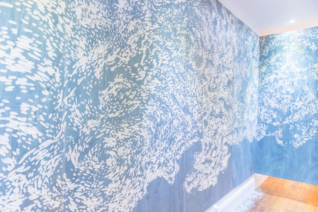 Mur avec motif artistique bleu et blanc.