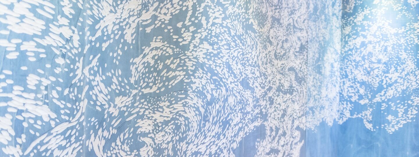 Mur avec motif artistique bleu et blanc.