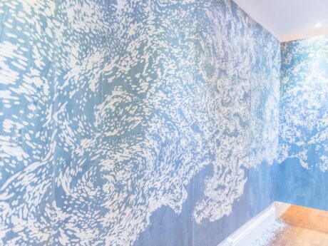 Mur avec motif artistique bleu et blanc.