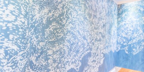 Mur avec motif artistique bleu et blanc.