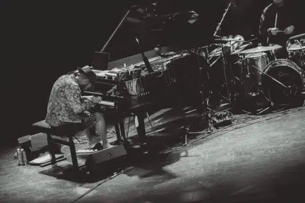 Pianiste jouant sur scène avec batterie.