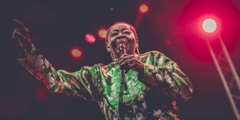 Chanteuse sur scène en chemise verte.