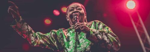 Chanteuse sur scène en chemise verte.