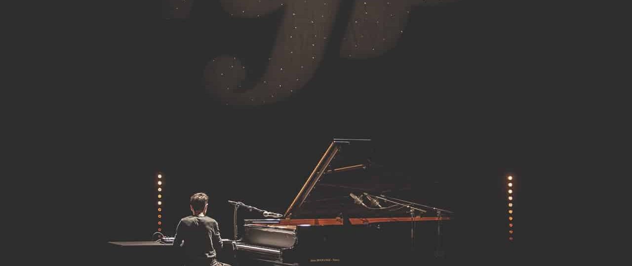 Pianiste en spectacle avec éclairage intense.