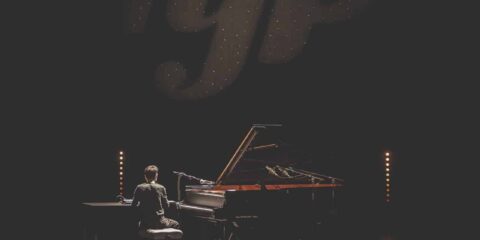 Pianiste en spectacle avec éclairage intense.