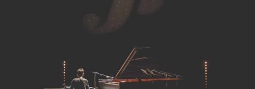 Pianiste en spectacle avec éclairage intense.