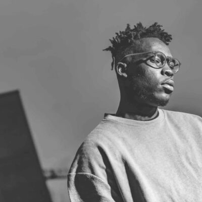 Homme avec lunettes en extérieur urbain.