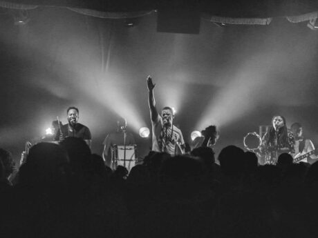 Groupe de musique en concert sur scène éclairée.