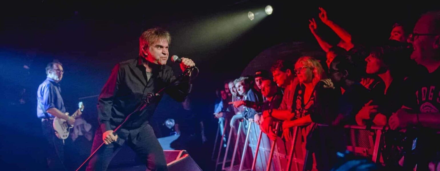 Chanteur en concert devant un public enthousiaste.