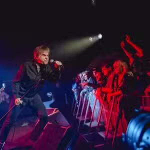 Chanteur en concert devant un public enthousiaste.