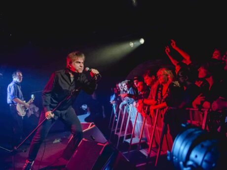 Chanteur en concert devant un public enthousiaste.