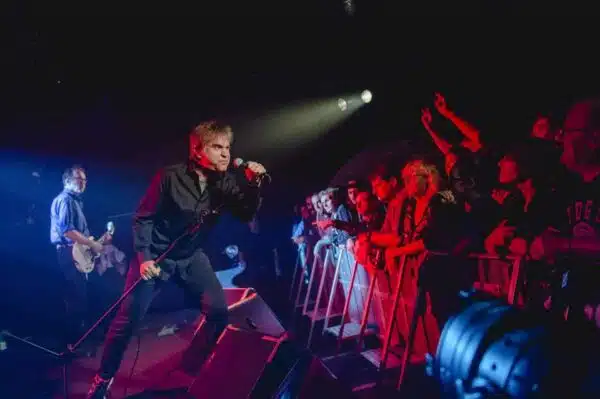 Chanteur sur scène avec la foule enthousiaste.