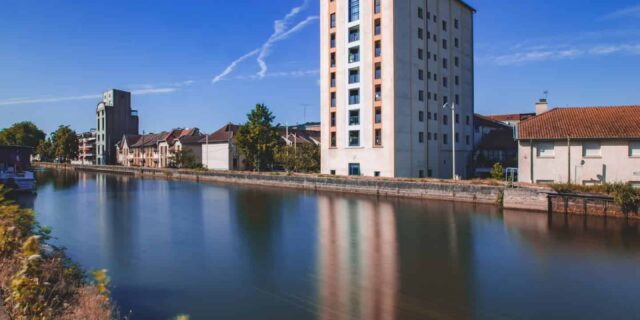 Immeuble près d'une rivière sous ciel bleu.