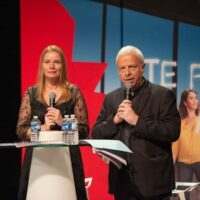 Deux personnes parlent sur scène avec micros.