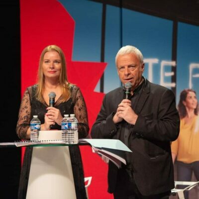 Deux personnes parlent sur scène avec micros.
