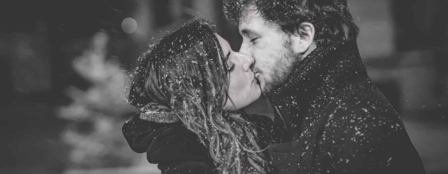 Couple s'embrassant sous la neige.
