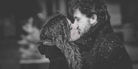 Couple s'embrassant sous la neige.