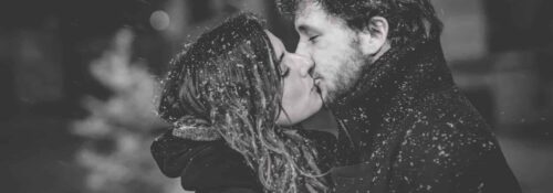 Couple s'embrassant sous la neige.
