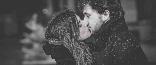 Couple s'embrassant sous la neige.