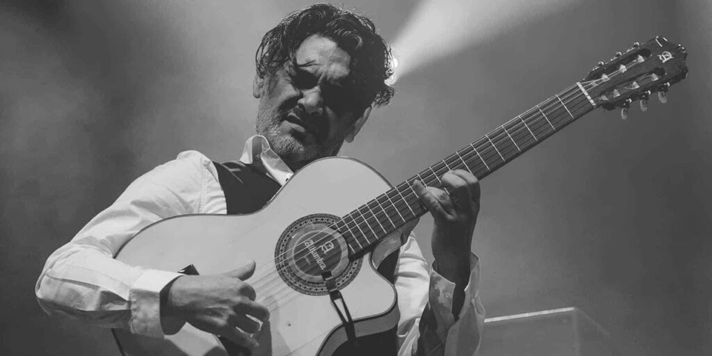 Musicien jouant de la guitare sur scène.