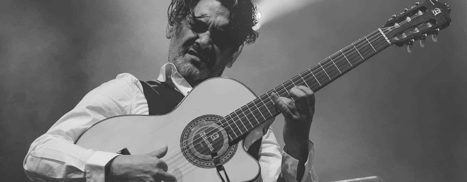 Musicien jouant de la guitare sur scène.
