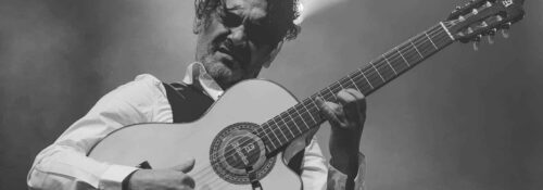 Musicien jouant de la guitare sur scène.