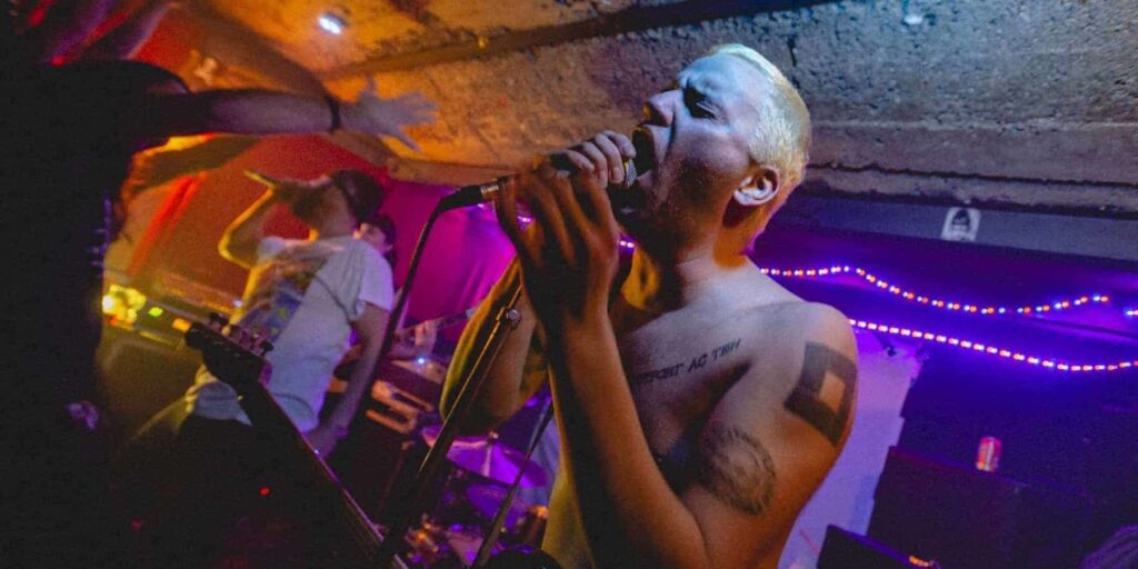 Concert rock underground avec chanteur tatoué.