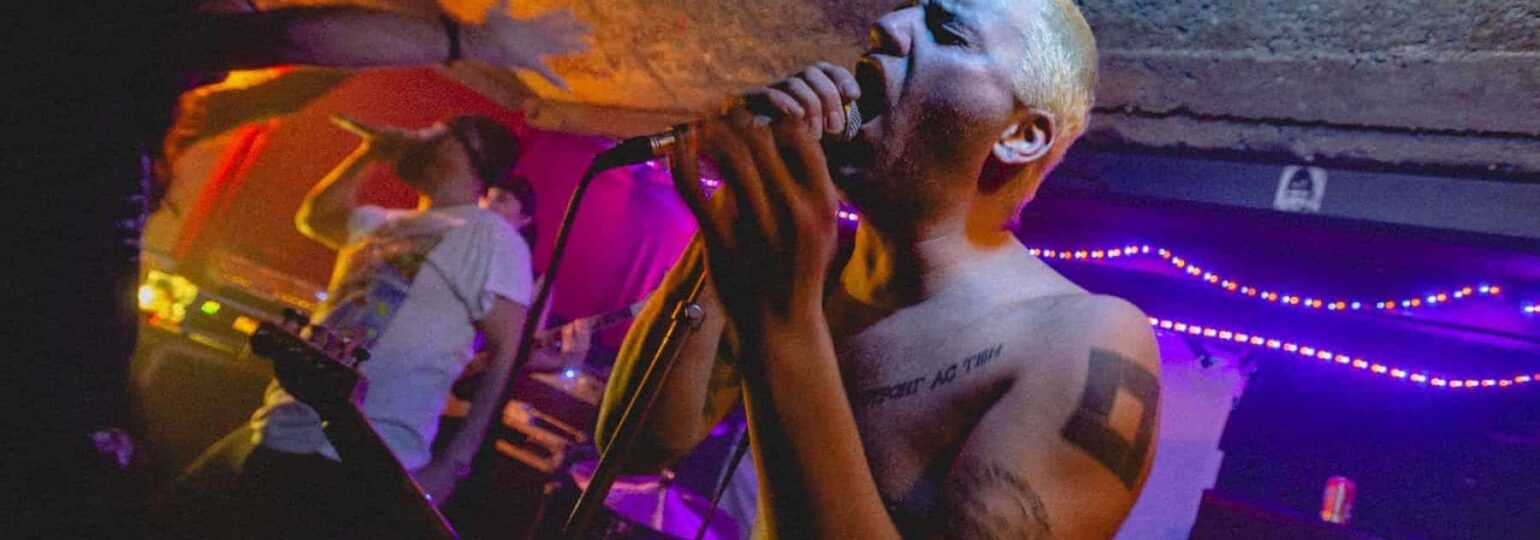 Concert rock underground avec chanteur tatoué.