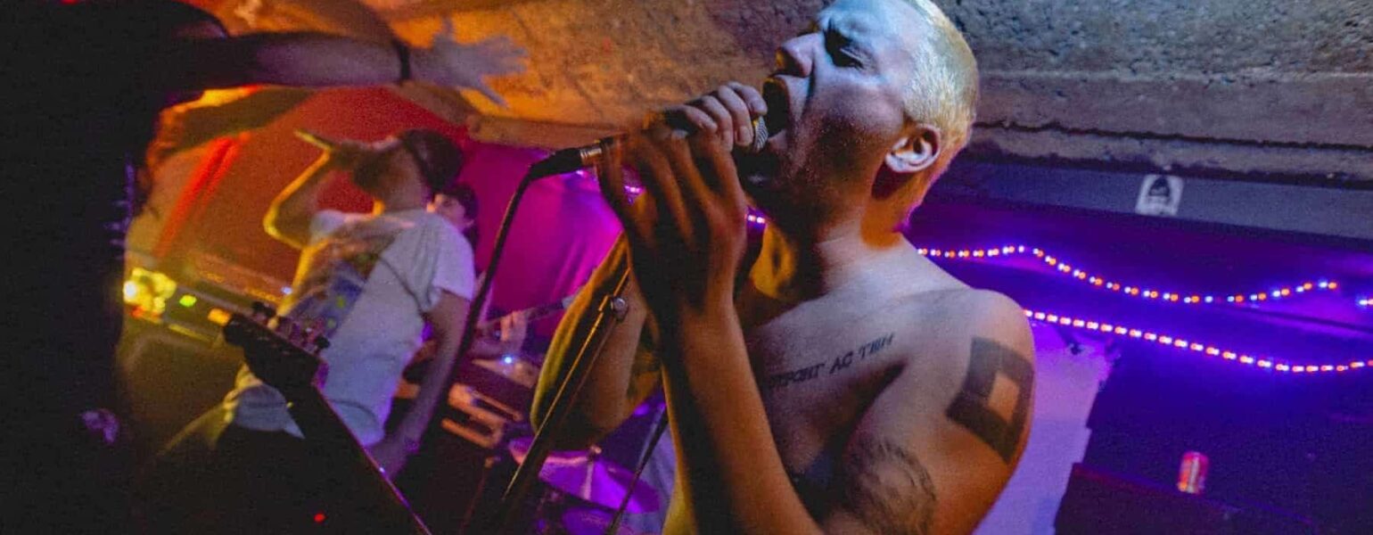 Concert rock underground avec chanteur tatoué.