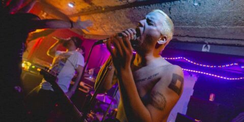 Concert rock underground avec chanteur tatoué.