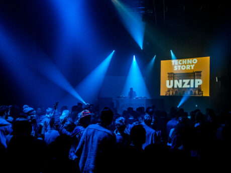 Ambiance en pleine fête électro pendant une soirée Techno Story, lumière sombre et public dansant.