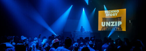 Ambiance en pleine fête électro pendant une soirée Techno Story, lumière sombre et public dansant.